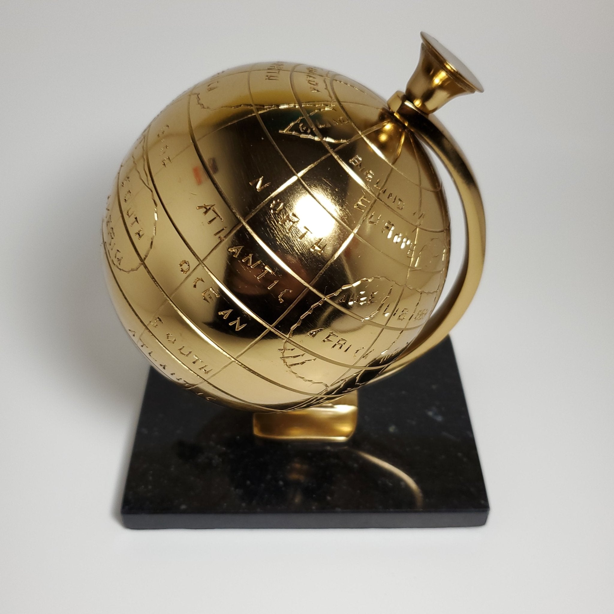 Gold decorative globe with black granite base close view