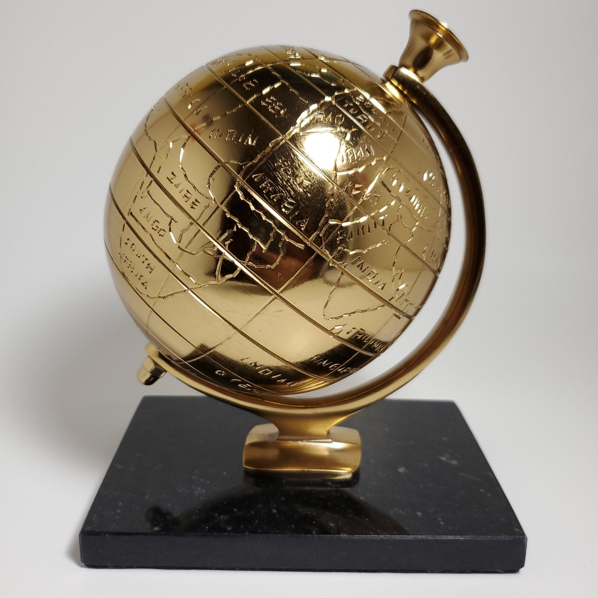 Gold decorative globe with black granite base front view