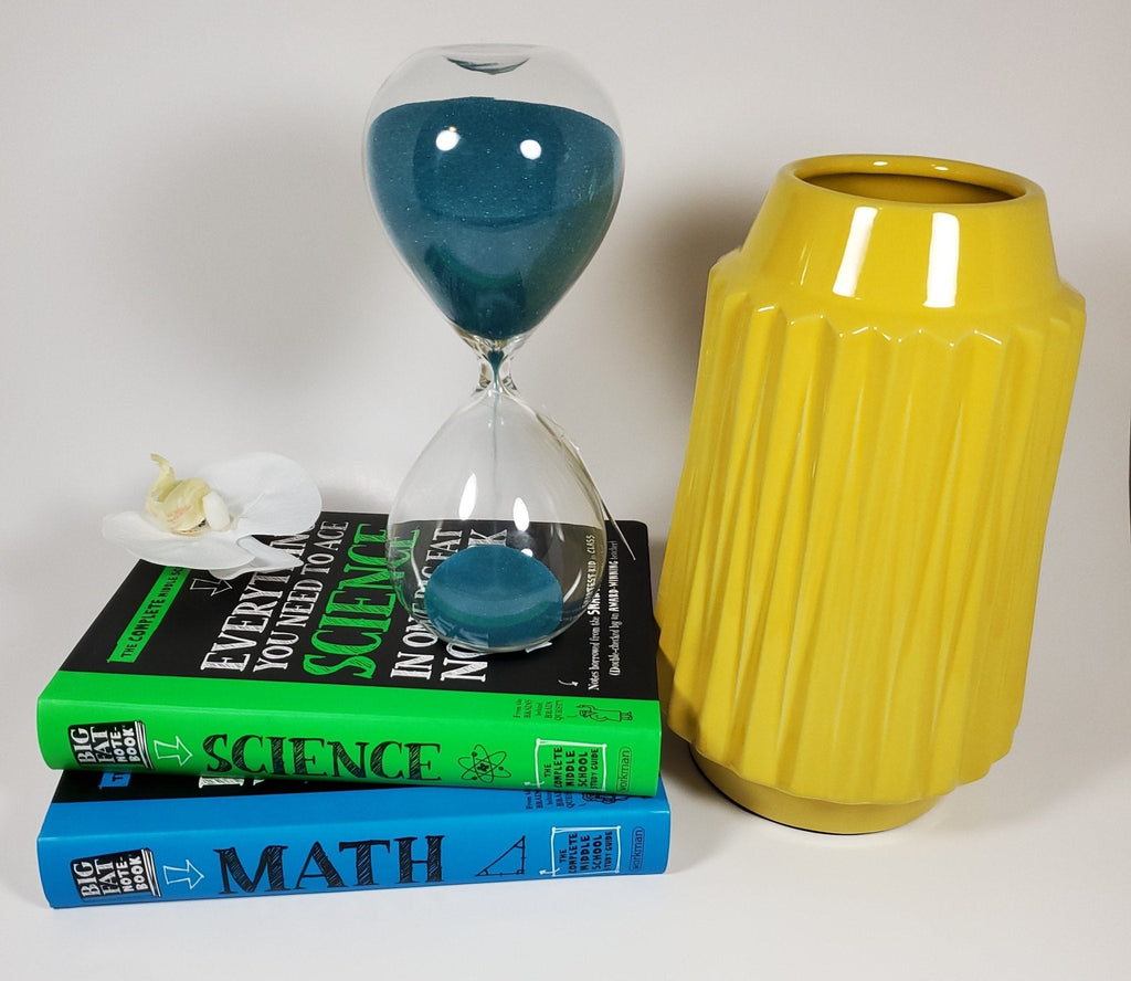 Sunshine yellow ribbed ceramic vase paired with books and hour glass